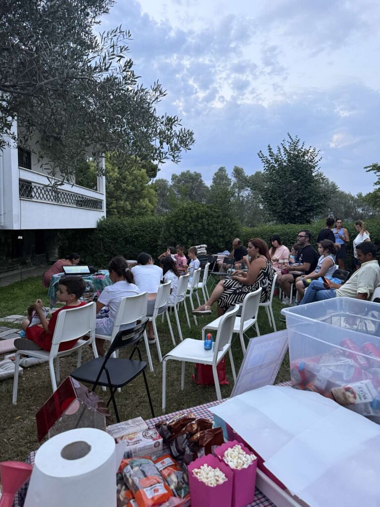 Παιδιά και γονείς αναμένουν την έναρξη της προβολής στην αυλή του ΜΑΖΙ!